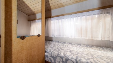 Příjemná venkovská zahrada s rekreačním karavanem a terasou.